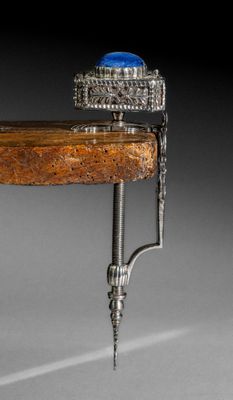 une photo d'une bague en argent sertie d'une pierre bleue, posée sur une table en bois