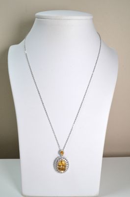 yellow and white diamond pendant on a white mannequin necklace