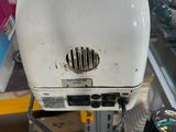 a white toaster sitting on top of a metal rack