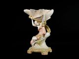 une figurine représentant une femme assise sur un coquillage