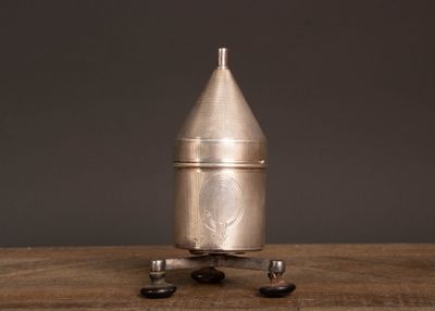 a silver metal object sitting on top of a wooden table