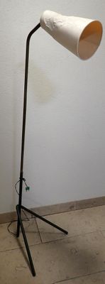 a lamp that is on a tripod stand in a room