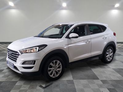un SUV blanc garé dans un garage au sol carrelé