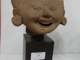 an image of a clay head of a person with a smile on it