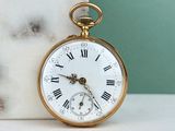 une montre de poche en or avec des chiffres romains