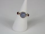 a close up of a ring on a white cone with a blue stone