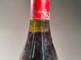a bottle of wine with a red cap sitting on a table
