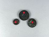 a close up of three small metal buttons on a white surface