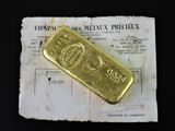 un lingot d'or posé sur une feuille de papier