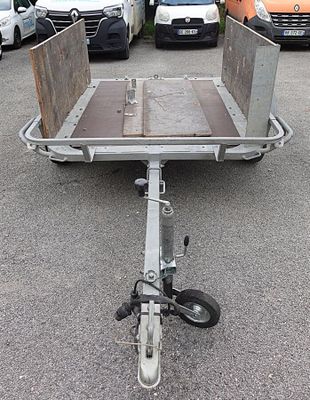 vehicles parked in a lot with a trailer attached to it