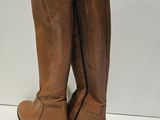 a pair of brown boots sitting on top of a white surface