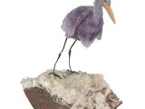 une figurine représentant un oiseau perché sur un rocher
