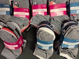 several pairs of socks are stacked on a table in front of boxes