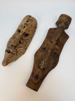 deux morceaux de bois sculpté sont posés sur une surface blanche