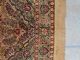 an image of a rug on a tiled floor with a cat laying on the floor