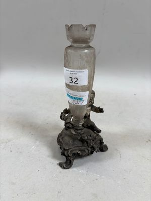 un vase en argent posé sur une table, sur lequel est collé un autocollant