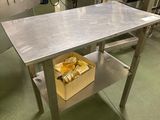 une table sur laquelle se trouve un panier rempli de nourriture, au milieu d'une cuisine