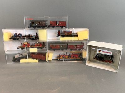 plein de petits trains miniatures dans une boîte posée sur la table