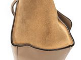 the back view of a tan purse with a black handle
