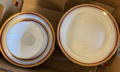 deux assiettes dans une boîte en carton, ornées d'une bande rouge