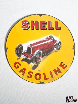 un panneau indiquant « Shell » sur le côté d'un mur blanc