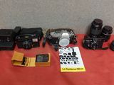 a group of cameras sitting on top of a table next to a book