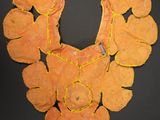 an image of a necklace made out of orange leaves on a black surface