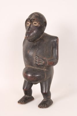 statue représentant un singe tenant un morceau de bois dans la main droite