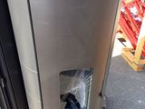 a silver refrigerator sitting on a pallet in a warehouse