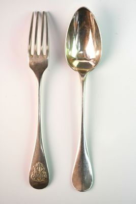 two spoons and a fork on a white surface