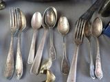 a lot of silver spoons and spoons on a table
