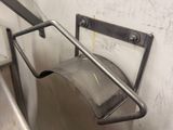 a toilet with a metal hand rail in a bathroom