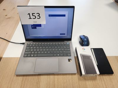 un ordinateur portable posé sur une table, à côté d'une souris et d'un téléphone portable
