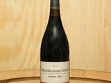 une bouteille de vin posée sur un tonneau en bois