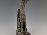 a bronze statue of a dog on a pedestal with a gray background