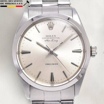 a silver watch with roman numerals on the face