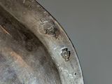 close up of a metal sculpture of a horse ' s head on a table