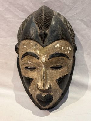 une image d'un masque en bois accroché au mur
