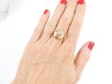 a woman ' s hand with a red manicure and a gold ring