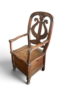 a wooden chair that has a harp on the back of it