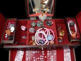 a red jewelry box with many different items in it
