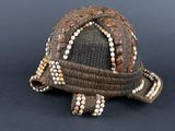 a small turtle made out of shells on a black surface