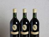 trois bouteilles de vin posées sur une table en bois