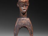 a wooden sculpture of a woman ' s head on a stand