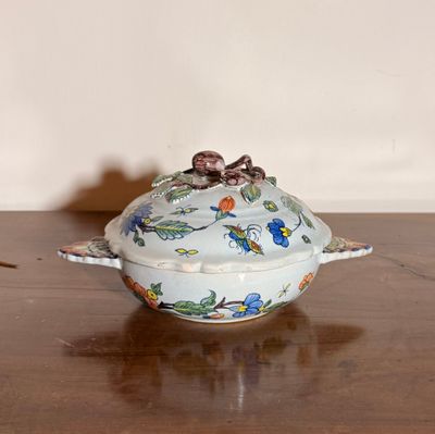 un petit bol muni d'un couvercle posé sur une table en bois