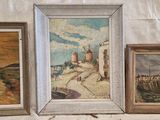 trois tableaux posés sur une table recouverte d'une nappe blanche