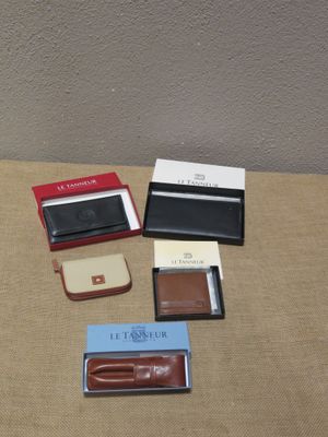 quatre modèles différents de portefeuilles et un porte-cartes posés sur une table