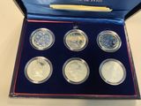 a set of six silver coins in a blue box