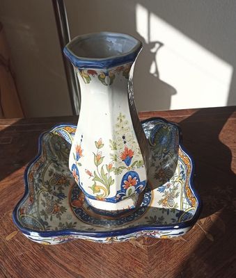 un vase posé sur un plateau, lui-même posé sur une table, avec une lampe en arrière-plan