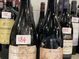 several bottles of wine are lined up on a counter